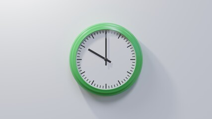 Glossy green clock on a white wall at ten o'clock. Time is 10:00 or 22:00