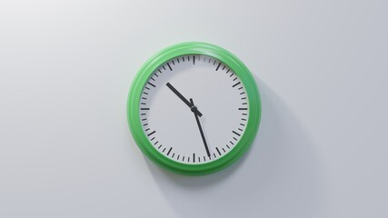 Glossy green clock on a white wall at twenty-seven past ten. Time is 10:27 or 22:27