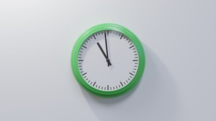 Glossy green clock on a white wall at fifty-nine past ten. Time is 10:59 or 22:59