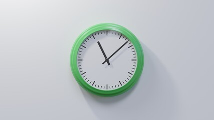 Glossy green clock on a white wall at eight past eleven. Time is 11:08 or 23:08