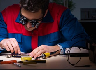 Computer specialist repairing PC late at night