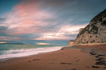 The sun rises over the English Channel at Durdle Door on the Jurassic Coast in Dorset