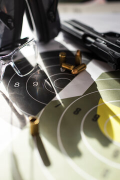 Shooting target with ammunition, pistol, ballistic glasses and headphones