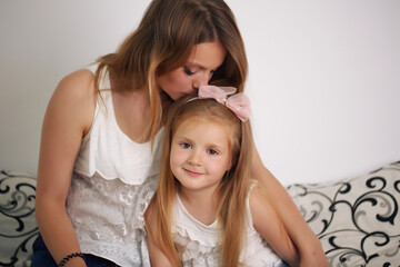 Mother and daughter enjoying on the bed, happy smiling