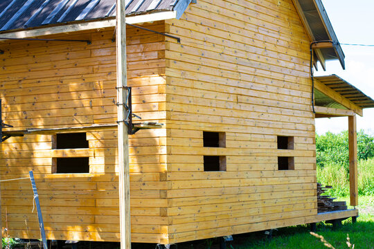 New wooden house made of logs and planks. Bright sunny day. Close-up photo.