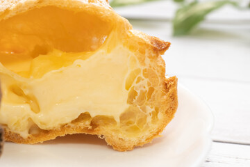 白い皿にのせた2つに割ったシュークリーム