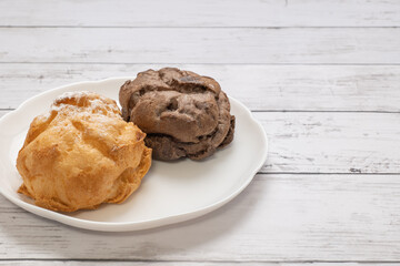 白い皿にのせた2種類のシュークリーム
