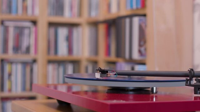 Stopping a blue vinyl lp on a record player and removing stylus