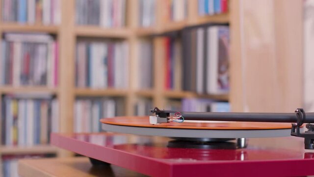 Stopping an orange vinyl lp on a record player close up
