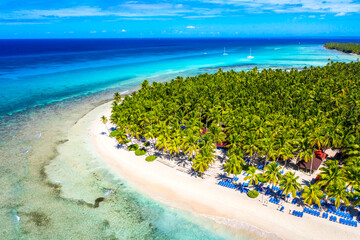 Top aerial drone view of beautiful beach with turquoise sea water, boats and palm trees. Saona island, Dominican republic. Paradise tropical island nature background