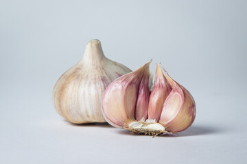 Garlic on a white background. Half a garlic next to a whole garlic. Agriculture concept