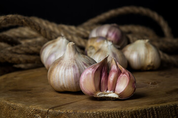 Garlic. A bunch of garlic lies on a wooden cutting board. Jute rope in the background. Agriculture concept