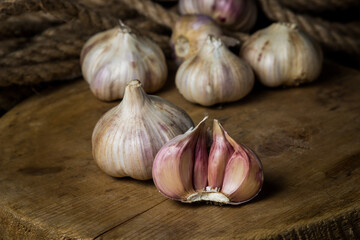 Garlic. A bunch of garlic lies on a wooden cutting board. Jute rope in the background. Agriculture concept
