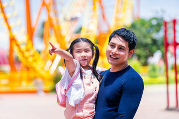 Father and daughter play at the amusement park. Family in theme park.