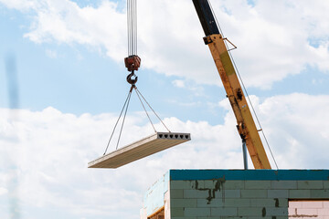 Builder worker installing concrete floor slab panel at building construction site