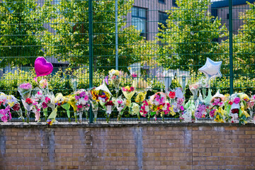 Many flowers in memorial at school for road accident death 