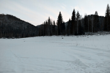 Mountain winter landscape of a snowy valley. Snowy winter mountains. The cold Siberian climate.