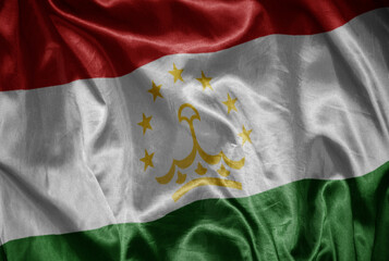 Fototapeta premium colorful shining big national flag of tajikistan on a silky texture