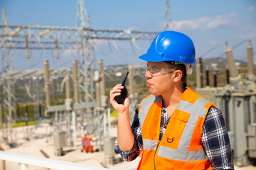 Businessman using walkie-talkie against power plant