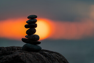 A small cairn placed on a rock at sunset