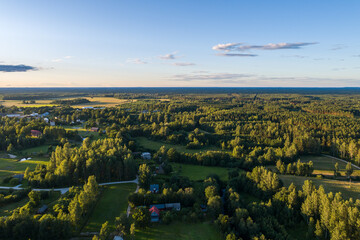 Beautiful sunset over the small town. Fields and trees around. Aerial photography.