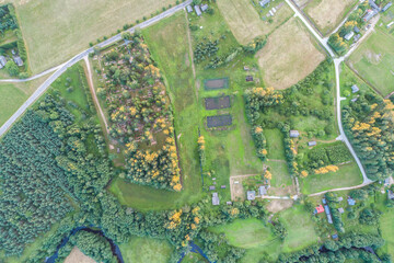 Beautiful sunset over the small town. Fields and trees around. Aerial photography.