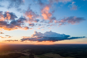 Beautiful sunset over the small town. Fields and trees around. Aerial photography.