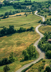 Fototapeta na wymiar Hilly curvy road without traffic through the hills of the Northern Apennines. Bardi, Parma province, Emilia Romagna, Italy.