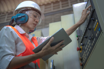 Woman engineering in charge of working duty in dashboard controller of the machine operation in manufactory warehouse