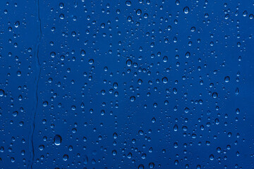 raindrops on glass with a blue tint