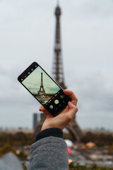 Ein Foto von einem Handy mit aktivierter Kamera mit Blick auf den Eifelturm in Paris