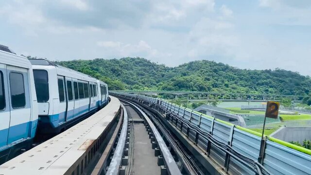 High speed footage of the Taipei metro in Taiwan.  Taipei metro train leaving station with natural view, and a train moving in to the platform.