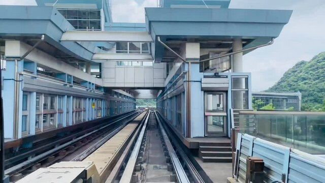 High speed footage of the Taipei metro in Taiwan.  Taipei metro train moving into the platform with cityscape view.