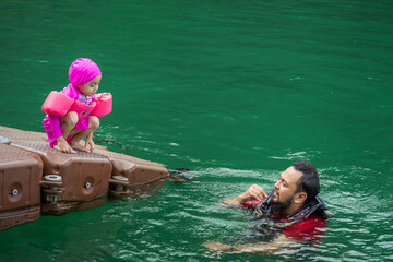 Asian family swimming at the Kenyir Lake, Malaysia.