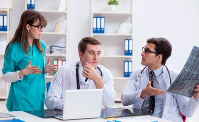 Three doctors discussing scan results of x-ray image