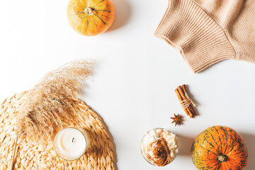 Fashion flat lay with beige caramel casual sweater with pumpkins, latte and spices, pampas grass on white background