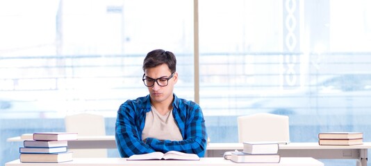 Student studying in the empty library with book preparing for ex