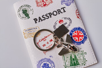 Close up passport cover with stamps. Metal charm trinket isolated on white background.