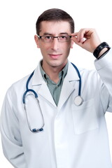 Fototapeta premium Young man in a white doctor’s coat with a stethoscope posing on a white background in isolation