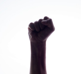 Backlight of a Hand with clenched a fist, isolated on a white background. Struggle and resistance concept. Freedom