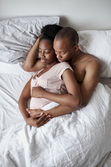 young african american couple has a calm, serene sleep at home. careful man hugs his pregnant wife, love concept