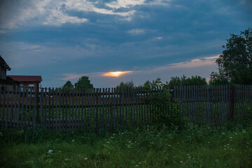  Village sunset. Sunset in the village. Wooden fence at sunset background