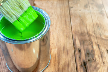 Paint brush and can on wooden surface