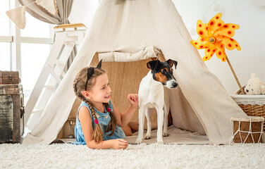 Little girl in wigwam with fox terrier © tan4ikk