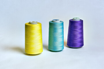 Sewing thread rolls in different colors on white background
