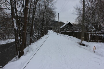 Narrow road by the river covered in snow