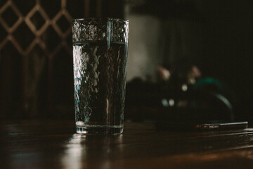 beautiful glass with water and a phone on the table in a cafe