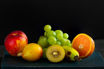 A set of fresh exotic fruits for making a fresh smoothie. Grapes, plum, orange, kiwi, banana and peach.