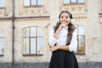 Fototapeta premium Happy kid outdoors. Cheerful schoolgirl. Schoolgirl listening music. Happy childhood concept. International childrens day. Sing with me. Smiling pupil. Real success. Happy song. Leisure and rest