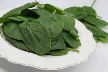 Fresh spinach leaves in a plate. Juicy spinach leaves. Spinach green fresh leaves.